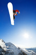 Snowboarder jumps in air with blue sky background