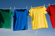 A row of colorful row t-shirts hanging on hangers