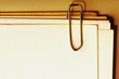 close-up view of a paper clip with stack of blank paper