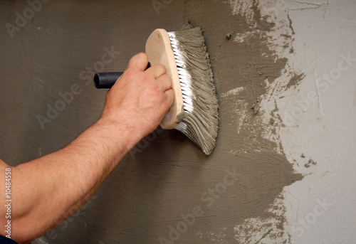 Photo: applying parget on the wall with a brush applying parget on the wall with a brush