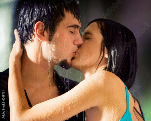 young couple kissing in the rain. Young hugging couple kissing