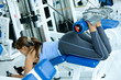 woman at the gym doing back exercises on a machine