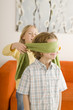 Boy (6-7) and girl (8-9) playing Blind Man's Bluff