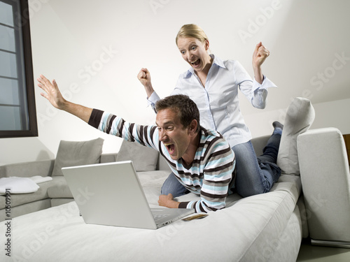 Photo: Couple on sofa, using laptop Couple on sofa, using laptop