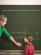 Teacher explaining arithmetic problem to girl (4-7)