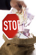 man taking money out of a sack, stop sign