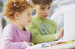 Boy and girl (7-9) using laptop