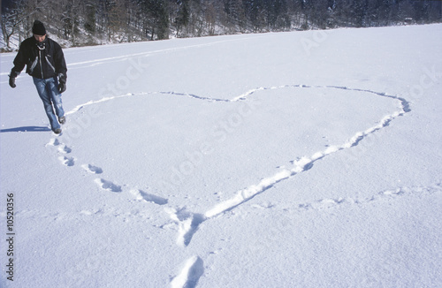 Foto: Man walking in snow, making heart shape by footprint Man walking in snow, making heart shape by footprint