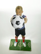 Boy (8-11) holding football on pitch