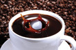 Sugar cube falling in cup of coffee