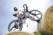 Mountainbiker standing on hay bales, low angle view
