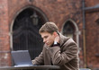 Young men hardly thinking near the laptop outside