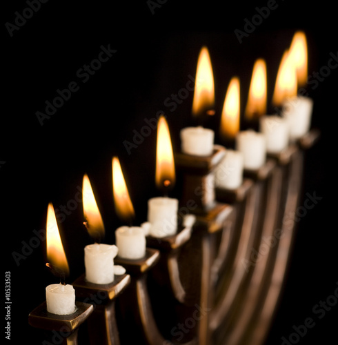 Photo: Beautiful lit hanukkah menorah on black. Beautiful lit hanukkah menorah on black.