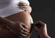 pregnant woman being examined by a doctor with stethoscope