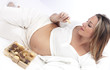Pregnant woman in bed eating chocolate smiling