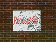 Brick wall of home with faded reposession poster