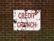 Brick wall of home with faded credit crunch poster