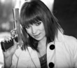 Black and white picture of lovely smiling girl with a gun