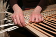 Female hands manually mastering wicker fabric Female hands manually mastering wicker fabric