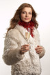 Young beautiful woman in white fur coat with glass of champagne