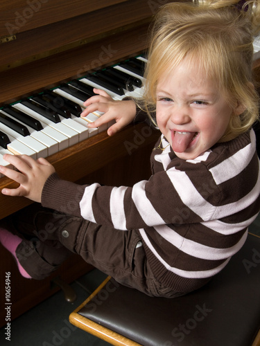 Photo: Kind musiziert auf einem Klavier Kind musiziert auf einem Klavier