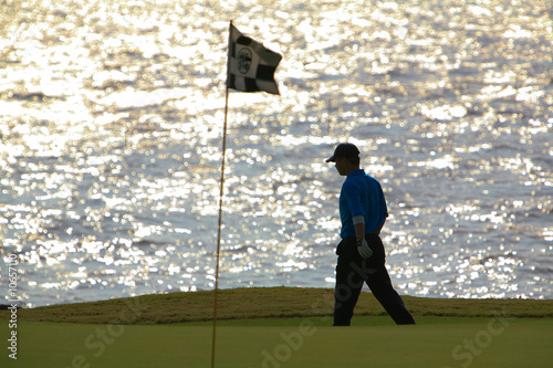 Photo: golfer walking towards the hole golfer walking towards the hole
