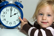 Kind mit Uhr als  Symbol Sommerzeit Umstellung