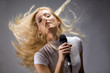 beautiful blond young woman singing into a microphone beautiful blond young woman singing into a microphone