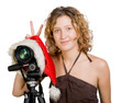 Girl and digital photo camera in a santa clause cap