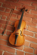 Violin & bow over red brick wall