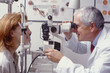 optometrist with patient, giving an eye examination optometrist with patient, giving an eye examination