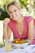 Woman Enjoying A Salad In A Garden