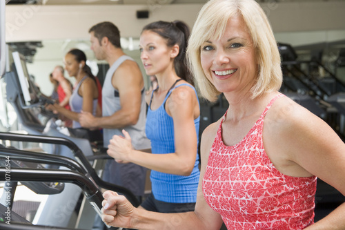 Photo: Woman Running On Treadmill At Gym Woman Running On Treadmill At Gym