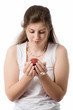 beautiful girl looks at apple on palms