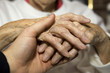 Young man 's hand holding senior's hand