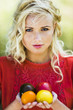 Young woman holding four colored tomatoes