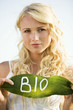 Young woman holding a leaf with "BIO" lettering