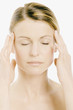 Young Woman face with make up, shut eyes, putting her hands on her temples (studio)