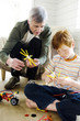 Senior man and boy playing construction game indoors