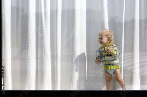 Photo: Little boy standing behind window Little boy standing behind window