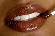 Young woman applying lipstick, close-up