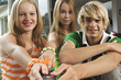 2 teenage girls and teenage boy using remote control