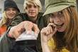 2 teenage girls and teenage boy using remote control