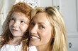 Photo: Christmas day, portrait of a mother and daughter smiling, looking at the camera, indoors Christmas day, portrait of a mother and daughter smiling, looking at the camera, indoors