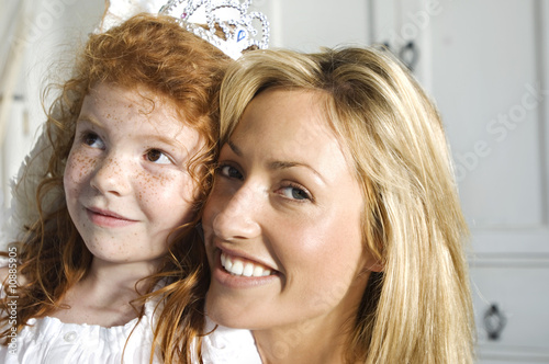 Photo: Christmas day, portrait of a mother and daughter smiling, looking at the camera, indoors Christmas day, portrait of a mother and daughter smiling, looking at the camera, indoors