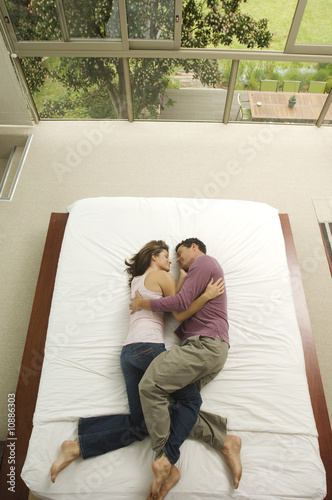 Photo: Couple sleeping in a bed, view from above, indoors Couple sleeping in a bed, view from above, indoors