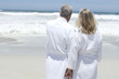 Couple in bathrobe looking out to sea, rear view