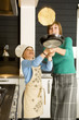 Young woman flipping a pancake with her son