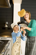 Young woman flipping a pancake with her son