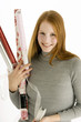 Portrait of a young woman holding rolls of wrapping papers and smiling